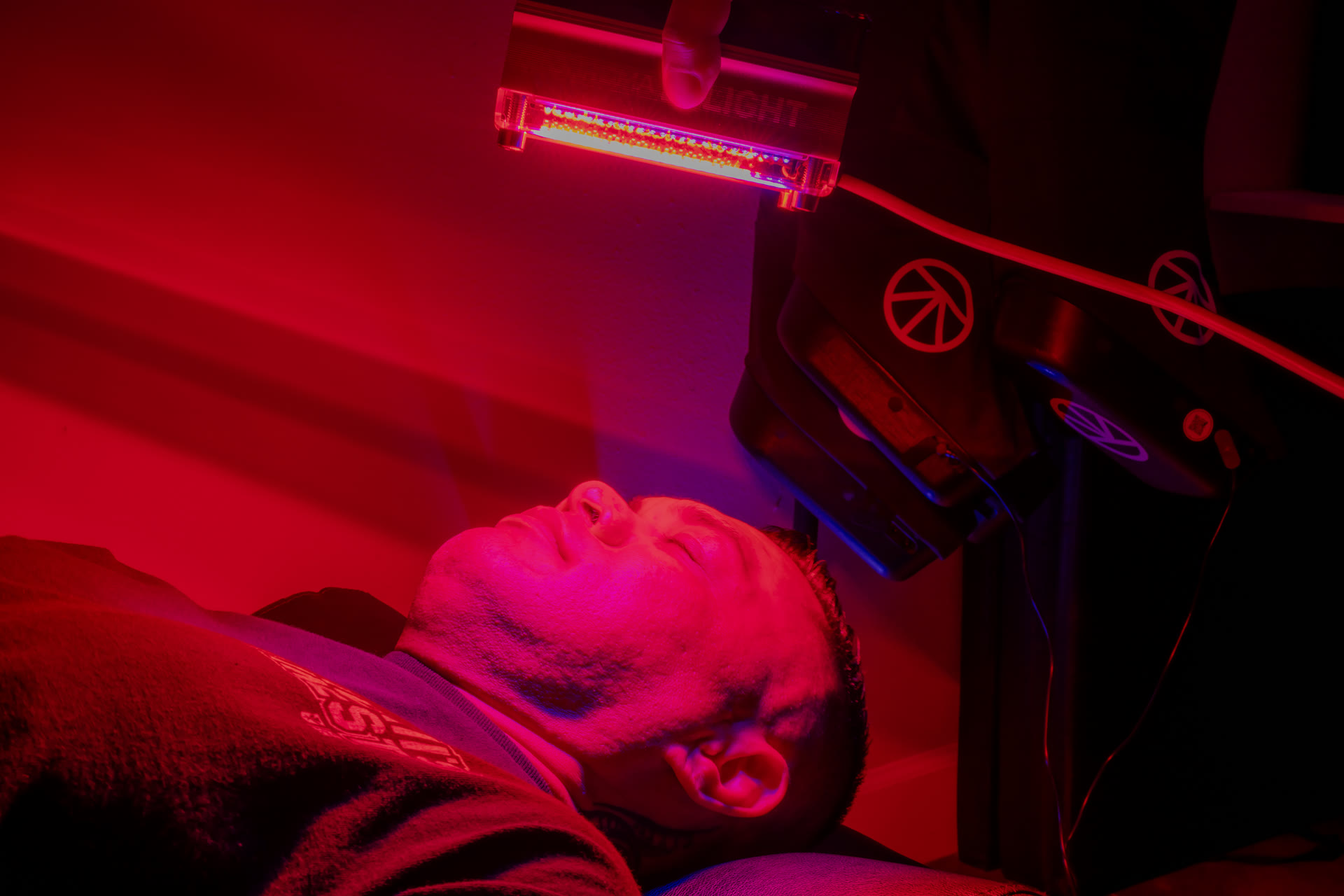 Red light therapy session — the light bar held over a member